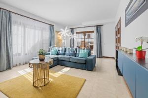 uma sala de estar com um sofá azul e uma mesa em Casa del Mar - Piscina y Jacuzzi Privado em Costa Teguise