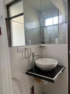 a bathroom with a sink and a mirror at Casa Blanca cerca al Mar in Máncora