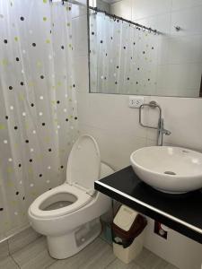 a bathroom with a white toilet and a sink at Casa Blanca cerca al Mar in Máncora