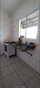 une cuisine avec un comptoir et une fenêtre. dans l'établissement Casa em Holambra- Sp, à Holambra