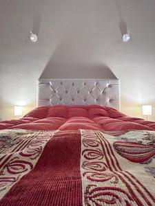 a bedroom with a large bed with a red blanket at Güemes Apart in San Juan