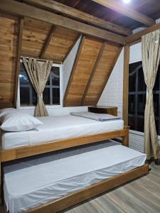 2 camas en una habitación con techos y ventanas de madera en Chalet Los Sinsontes, en San Rafael