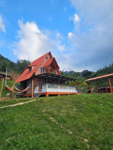 a building with a red roof on top of a field at Chalet Los Sinsontes in San Rafael