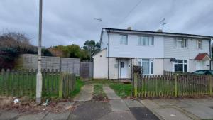 a white house with a fence in front of it at Central Haven-5bedroom Great For Longer Stays In Canterbury kent!!! in Kent