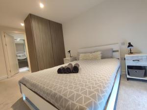 a bedroom with a bed with shoes on it at Luxury Riverside Apt with easy access to Central London, O2, Excel centre and Parking in Woolwich