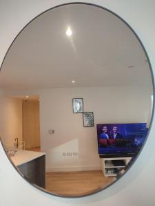 a mirror reflecting a living room with a tv at Luxury Riverside Apt with easy access to Central London, O2, Excel centre and Parking in Woolwich