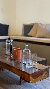 a wooden table with two glasses and a bottle on it at Taura in Antigua Guatemala