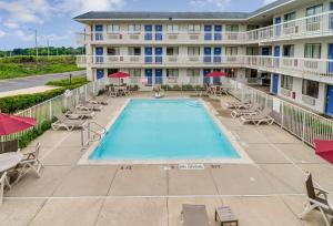 una imagen de una piscina en un hotel con sillas y sombrillas en Motel 6-Rolling Meadows, IL - Chicago Northwest en Rolling Meadows