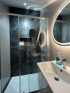 ein Bad mit einer Dusche und einem Waschbecken in der Unterkunft London Studios and Suites in Harrow