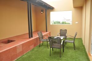 a patio with chairs and a table with grass at Hotel Atrium in Erode