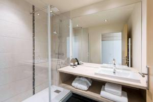 une salle de bain avec un lavabo et une douche dans l'établissement Best Western Plus Hôtel Escapade Senlis, à Senlis