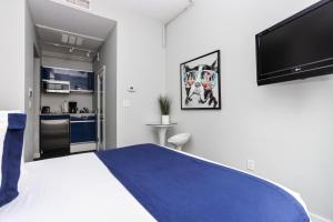 a bedroom with a large bed and a flat screen tv at Cozy Studio on Newbury Street, #1 in Boston