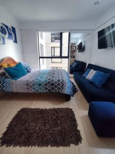 a bedroom with a bed and a couch at Aparta estudio en la candelaria WiFi rápido-a pasos del museo de oro in Bogotá