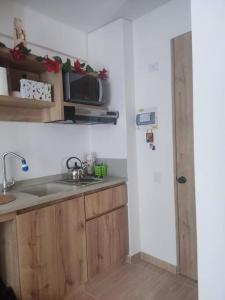 a kitchen with a sink and a microwave at Aparta estudio en la candelaria WiFi rápido-a pasos del museo de oro in Bogotá