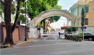 un arco sobre una calle en una ciudad con coches en Habitación amplia en casa grande y sola en Coapa, junto al Club America, cerca de Miramontes, Tlalpan, Periférico, en Ciudad de México