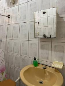 uma casa de banho com um lavatório e um espelho em Casa com terraço em Piúma. em Piúma