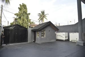 a small house sitting next to a black fence at ABODE APARTMENTS in Lagos