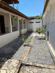 uma passagem de pedra em frente a um edifício em Casa com terraço em Piúma. em Piúma