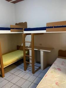 ピウーマにあるCasa com terraço em Piúma.の二段ベッド2台とベッド1台が備わる客室です。
