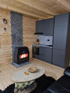 - un salon avec une cheminée et une table dans l'établissement Apartment Homeland, à Kolašin