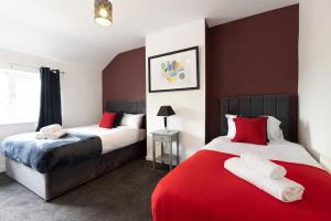 two beds in a room with red and white at Origin - Close 2 city-centre, Shops, Netflix in Kirkstall