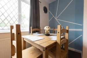a dining room table with two chairs and a wooden table at Origin - Close 2 city-centre, Shops, Netflix in Kirkstall