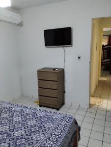 a bedroom with a bed and a tv on a wall at Casa em Tamandaré a 1km de Carneiros no Condomínio Cote d' Azur in Tamandaré