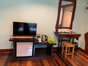 a desk with a television on it with a mirror at Baan Pongam Resort in Ao Nang Beach
