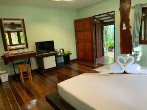 a bedroom with a bed and a television in a room at Baan Pongam Resort in Ao Nang Beach