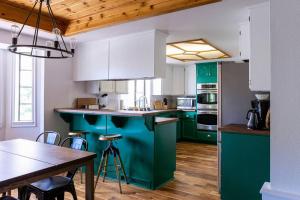 a kitchen with green and white cabinets and a table at Apres-Ski Chalet Mt High Wrightwood Ski Resort in Wrightwood
