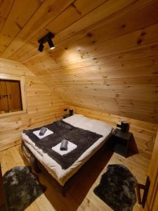 Cette chambre comprend un lit dans une cabane en rondins. dans l'établissement Apartment Homeland, à Kolašin