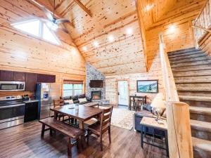a living room with a table and a kitchen and stairs at Indoor Heated Pool Hot Tub Cabin in Sevierville