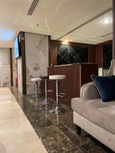 فندق لؤلؤة الصفا في Ajyad: غرفة معيشة مع أريكة وكراسي البار