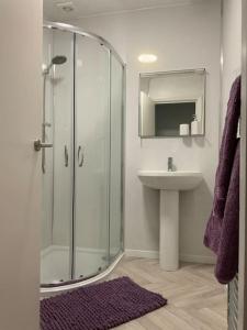 y baño con ducha acristalada y lavamanos. en Family friendly flat, Perfect for a Dorset escape, en Bournemouth