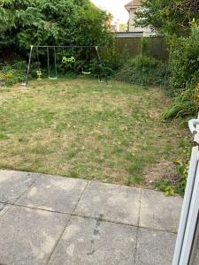 a yard with a swing set in the grass at Family friendly flat, Perfect for a Dorset escape in Bournemouth