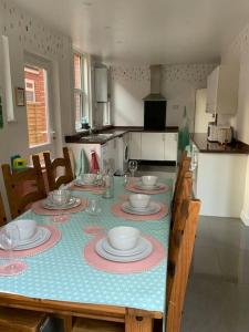 a dining room table with plates and dishes on it at Family friendly flat, Perfect for a Dorset escape in Bournemouth