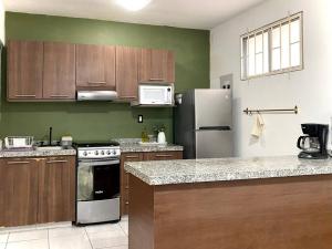 a kitchen with wooden cabinets and a stove and refrigerator at Apartamento Lúa in Veracruz