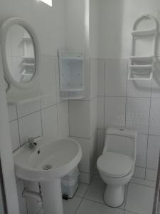 uma casa de banho branca com um WC e um lavatório em Misti em Tarapoto