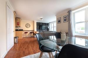 a living room with a glass table and chairs at Zircon - 2 Bed Flat with Parking in Southampton