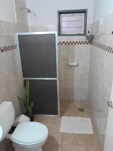 Un baño con ducha, inodoro y lavabo. en Departamento Itaembe Guazu, en Villa Dolores