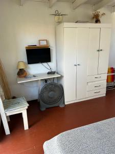 a bedroom with a desk with a monitor and a computer at Lunas del Bosque Cabaña y apartamento en suite in La Paloma