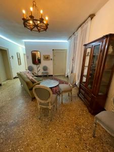 Lions Venice Guest house في البندقية: غرفة معيشة مع أريكة وطاولة وكراسي
