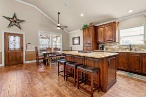 a kitchen with wooden cabinets and a table with bar stools at River Road Villas #2 in New Braunfels