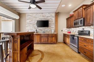 a large kitchen with wooden cabinets and a ceiling fan at River Road Villas #2 in New Braunfels +42 photos