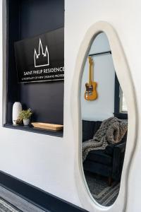 lustro w pokoju z krzesłem i gitarą w obiekcie Saint Philip Residence w Nowym Orleanie