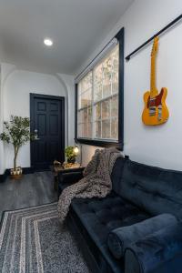sala de estar con sofá negro y guitarra en Saint Philip Residence en Nueva Orleans