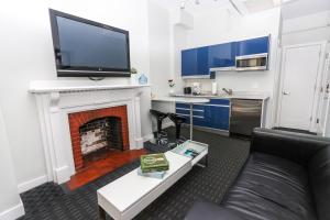 a living room with a couch and a fireplace with a flat screen tv at Stylish Newbury Street Studio, #2 in Boston