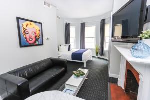 uma sala de estar com um sofá e uma cama em Stylish Newbury Street Studio, #2 em Boston