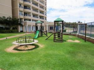a playground with two swings and a slide at Apartamento Beach Village Praia do Futuro by WL Temporada in Fortaleza