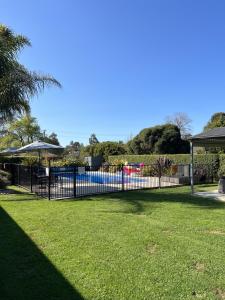 una valla negra en un patio con piscina en Alexandra Motor Inn - Victoria Aus, en Alexandra